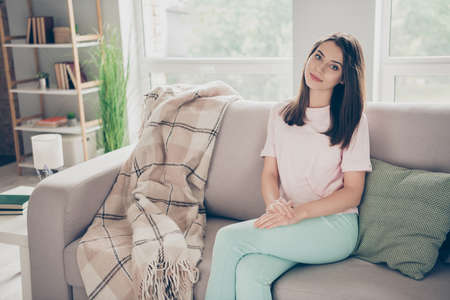 Photo portrait of young woman sitting on sofa with crossed legs indoors