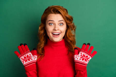 Photo of crazy amazed girl raise palms open mouth white smile wear red pullover mittens isolated...
