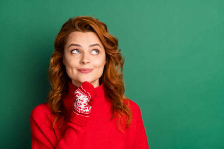 Photo of minded interested pretty girl finger chin look empty space wear red pullover mittens...