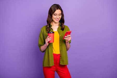 Portrait of positive cheerful girl use smartphone texting typing chatting chilling hold takeaway...