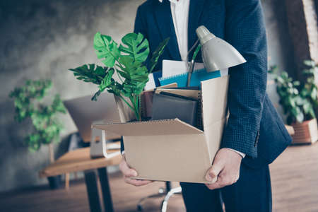 Cropped photo of dismissed worker guy laid off fired manager agent loser lost job work pack carry belongings carton box financial crisis crash modern workstation office indoorsの写真素材