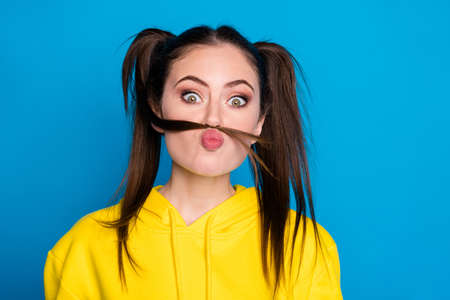 Close-up portrait of nice attractive lovely foolish childish cheery girl making fake mustache having fun leisure pout lips isolated over bright vivid shine vibrant blue color backgroundの写真素材