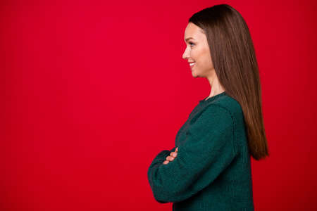 Profile side photo of attractive girl look empty space cross hands wear pullover isolated on red bright color backgroundの写真素材