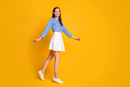 Full size profile side photo of friendly satisfied girl go walk spring free time weekend wear good look clothes sneakers isolated over shine color backgroundの写真素材