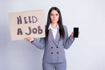 Need job use smartphone. Serious boss banker financier loss work hold modern technology browse market website wear checkered plaid pants trousers blazer isolated gray color backgroundの写真素材
