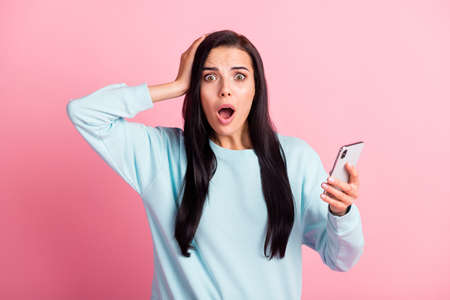 Attractive shocked blogger lady hold telephone dislike unfollow wear sweatshirt pullover isolated...