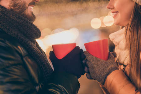 Cropped profile side photo of affectionate couple hold hot beverage mug celebrate x-mas spirit newyear wear season coat gloves outdoorsの写真素材