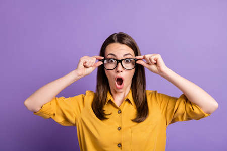 Photo of young lady hold specs open mouth wear eyewear yellow shirt isolated violet color backgroundの写真素材
