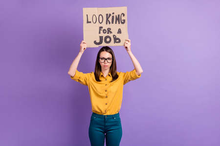 Photo portrait of female student keeping carton card over head looking for job isolated on vibrant...