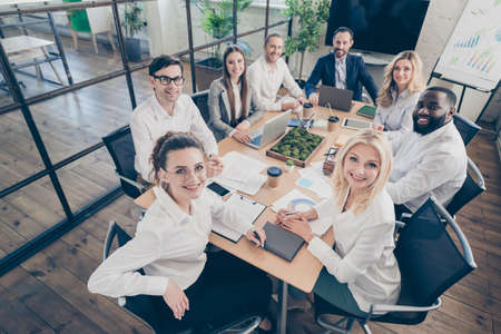 Photo of successful eight business diversity colleagues sit table friendly team professionals budget improvement reduction dismissal crisis problem good mood optimistic people office indoorsの写真素材
