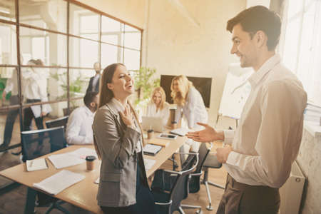 Profile side photo of positive cheerful colleagues man woman have talk say tell speak way-out crisis company briefing break laugh in boardroom workplace workstationの写真素材