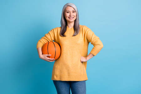 Photo of charming cute senior lady hold game ball hand hip smiling challenger coach ready start play...