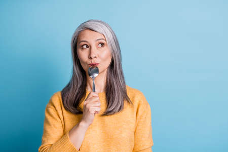 Close-up portrait photo of cute lovely retired old lady dreamy look lick spoon thinking imagining...