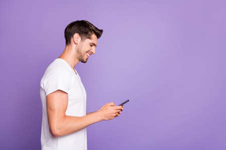 Profile side view portrait of his he nice attractive cheerful cheery focused guy using cell chatting...