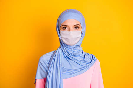 Close-up portrait of attractive serious content muslimah wearing blue pastel hijab white face mask...