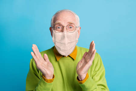 Photo of granddad raise palms wear white face mask isolated blue color background