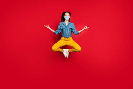 Full length photo of calm focused girl jumping sitting lotus pose meditating wear mask isolated...