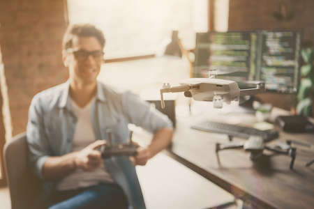 Portrait of his he blurred nice attractive cheerful cheery guy geek skilled specialist controlling...