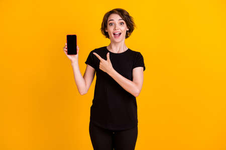 Portrait of attractive amazed cheerful girl showing device cellular advert look roaming isolated...