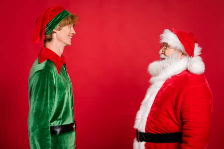 Profile photo of two people santa claus elf look each other wear x-mas costume coat headwear...