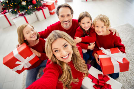 Photo of full big family five people gathering three small kids sit floor hold present box mom make...