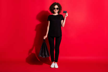 Full length photo of shiny wavy lady dressed casual black outfit eyewear holding shopping bags...