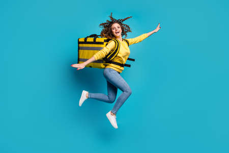 Full length body size view of nice attractive cheerful cheery glad funny funky wavy-haired girl jumping carrying takeaway meal having fun isolated bright vivid shine vibrant blue color backgroundの写真素材
