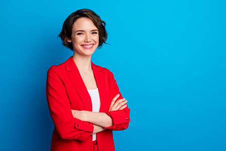 Portrait of nice attractive content cheerful lady folded arm copy empty space isolated over bright blue color backgroundの写真素材
