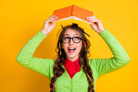 Close-up portrait of lovely funky clever cheerful teenage girl reading book literacy isolated over...