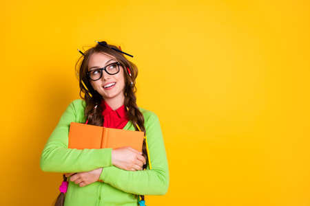 Portrait of pretty funky dreamy cheery creative intellectual girl hugging exercise book thinking...