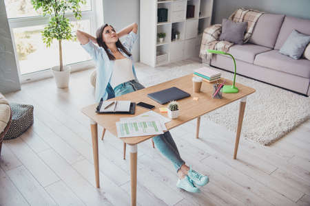 Photo of cute business lady arms behind head resting sit table look wear spectacles shirt in home...