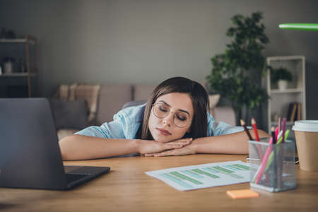 Photo of sleepy pretty girl head cozy lay hands closed eyes wear glasses shirt in home office...