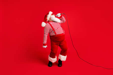 Full length body size view of his he handsome bearded talented Santa mc pj soloist vocalist star singing hit single having fun rest chill isolated bright vivid shine vibrant red color backgroundの写真素材