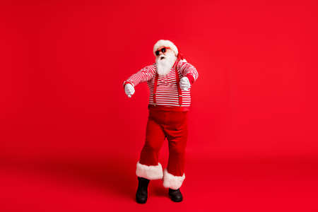 Full length body size view of his he nice handsome attractive cool cheerful cheery childish Santa dancing rest having fun fooling isolated bright vivid shine vibrant red color backgroundの写真素材