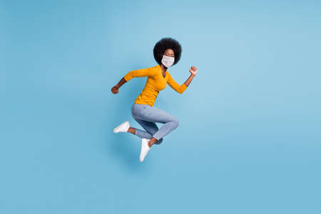 Photo portrait full size of woman running jumping up use medical respirator isolated on pastel blue colored backgroundの写真素材