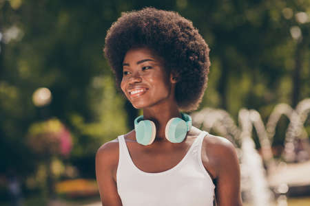 Photo of pretty afro american girl look on summer town center forest park wear white tank-top
