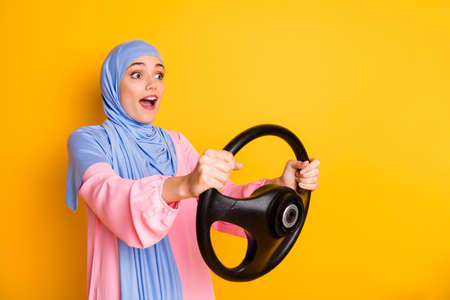 Profile side view portrait of pretty attentive amazed cheery muslimah wearing hijab driving...