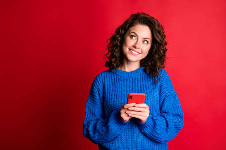 Photo of interested charming pretty lady wavy hairdo hold telephone look up empty space toothy...