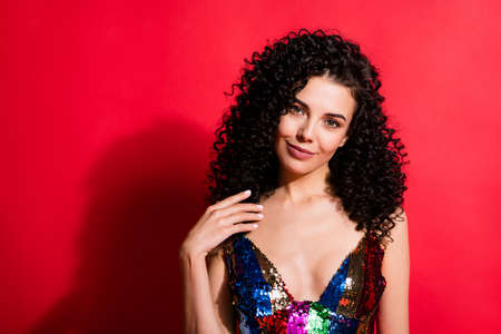 Close-up portrait of charming cheery wavy-haired girl wearing festal dress isolated over vibrant red...