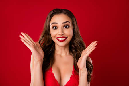 Photo portrait of pretty woman showing palms smiling isolated on vivid red colored background