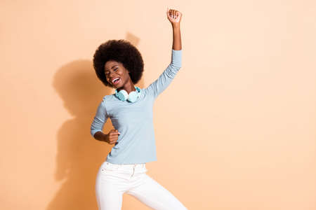 Photo portrait of carefree african american girl dancing with one fist in air isolated on pastel...