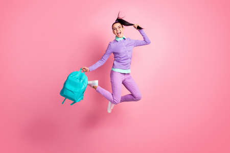 Full length photo of girl jump hold bag tail open mouth wear eyewear purple pullover pants sneakers...