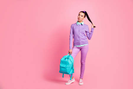 Full length photo of pretty lady play tail look empty space hold bag wear violet pullover pants...