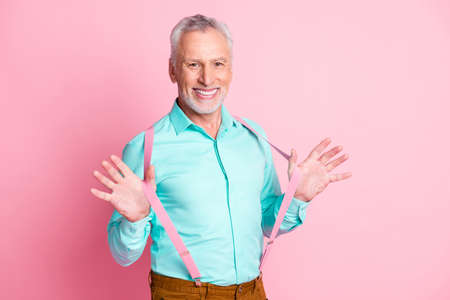 Photo portrait of grandfather dressing up wearing teal shirt suspenders smiling isolated on pink color backgroundの写真素材