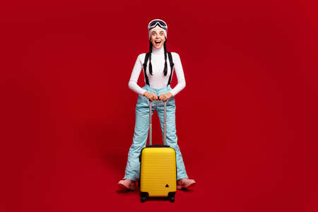 Full size photo of young happy excited crazy girl with tails wear blue pants hold luggage isolated...