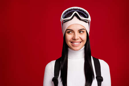 Portrait of young lovely cheerful happy good mood gir snowboarder smiling look copyspace isolated on red color backgroundの写真素材
