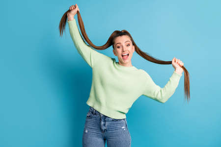 Portrait of her she nice-looking attractive lovely funky cheerful cheery brown-haired girl making tails having fun dancing isolated over bright vivid shine vibrant blue color backgroundの写真素材