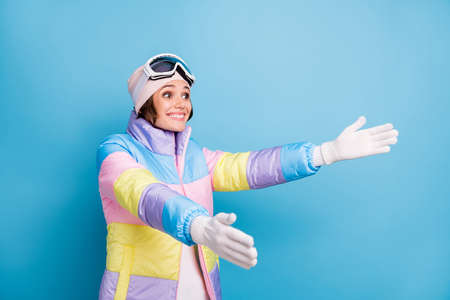 Photo of nice woman hug put out hands copyspace amazed ski vacation in mountains isolated on blue color backgroundの写真素材