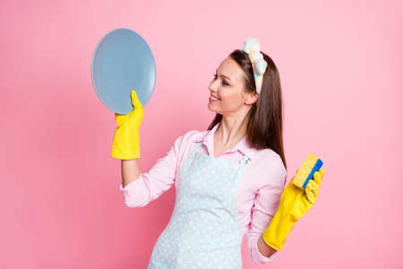 Portrait of nice attractive pretty lovely glad cheerful cheery professional brown-haired housemaid cleansing plate fast easy steps cleanup service isolated on pink pastel color backgroundの写真素材
