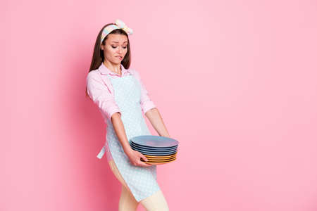 Portrait of her she nice attractive pretty sad overwhelmed tired brown-haired waitress holding in hands carrying heavy pile plates comfort service isolated on pink pastel color backgroundの写真素材